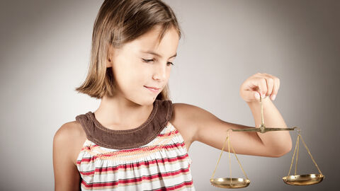 Mädchen hält Waage in der Hand.