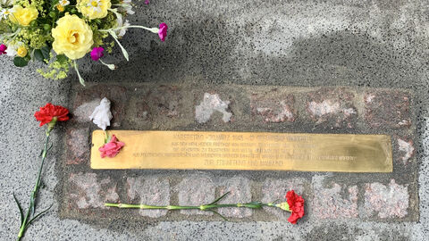 In den Boden eingelassene Stolperschnwelle, bestehend aus graviertem Text in Metell mit Steinen umrandet