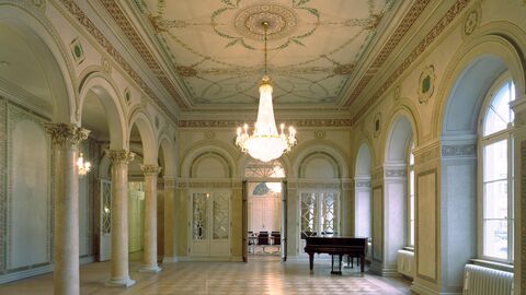 Thronsaal Thronsaal mit Kronleuchter, Wand- und Deckenmalereien, in der unteren Bildmitte ist der Durchgang zum Kleinen Sitzungssaal sichtbar, rechts daneben steht ein Flügel.