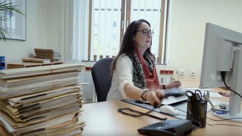 Rechtspflegerin sitzt an einem Schreibtisch