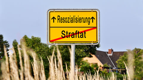 Symbolbild Resozialisierung Verkehrsschild Ortstafel mit Ankündigung "Resozialisierung" und "Straftat" verlassen.
