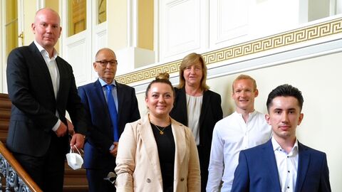Gewinner des Präventionspreises stehen auf einer Treppe.
