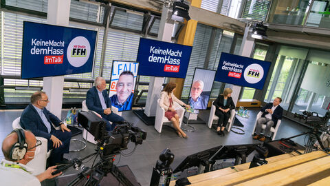 Gesprächsrunde II Aktionstag gegen Hasskrimininalität Gesamtaufnahme der Gesprächsteilnehmer bei der Podiumsdiskussion mit Kameramann und weiterer Technik.