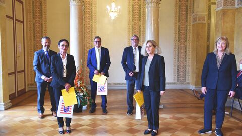 Sieben Personen im historischen Saal von links nach rechts: Dr. Frank Woitaschek (Präsident des Hessischen Landesarbeitsgerichts), Lydia Appel-Moritz, Gerd Tausendfreund, Hans-Joachim Weis, Andrea Faulstich-Goebel, Justizministerin Eva Kühne-Hörmann