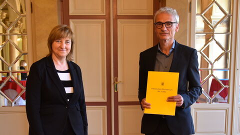 Justizministerin Eva Kühne-Hörmann mit Helmut Vogt, der seine Ernennungsurkunde in den Händen hält.