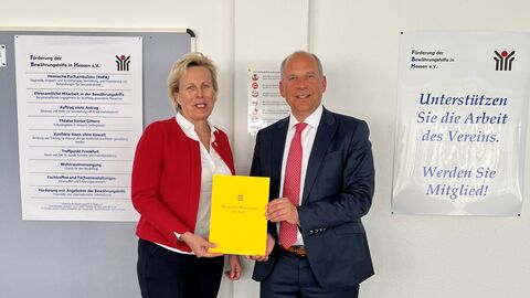 Justizminister Roman Poseck besucht den Verein Förderung der Bewährungshilfe in Hessen e.V. und übergibt Zuwendungsbescheide in Höhe von insgesamt 34.300,- Euro Justizminister Poseck übergibt den Förderbescheid, er lächelt in die Kamera