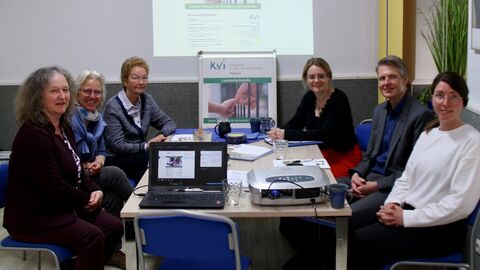 Menschen sitzen in einem Meetingraum mit Präsentation