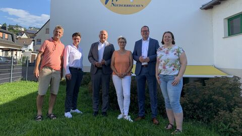 Justizminister Poseck mit Engagierten des Turnvereins gemeinsam auf einer Wiese. Sie stehen aufgereiht und lächeln in die Kamera. 