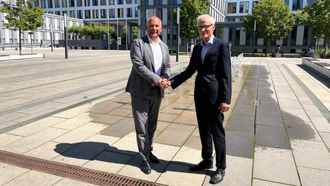 Justizminister Prof. Dr. Roman Poseck steht neben dem Präsidenten des Amtsgerichts Wiesbaden Helmut Vogt und schüttelt ihm die Hand