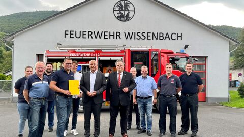 Justizminister Roman Poseck übergibt der Freiwilligen Feuerwehr Eschenburg-Wissenbach einen Förderbescheid in Höhe von fast 11.000 Euro