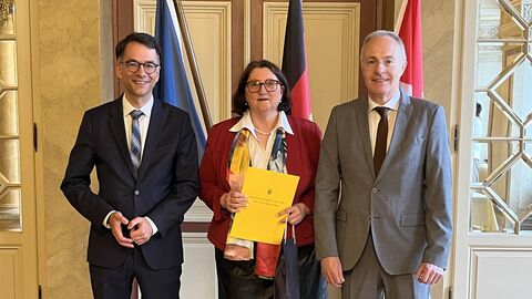 Justizminister Heinz neben Sabine Dörr und Dirk Schönstädt. Dörr (Mitte) hält den Versetzungserlass in Händen.