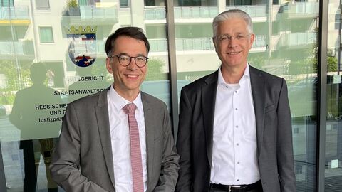 Justizminister Christian Heinz und der leitende Oberstaatsanwalt Peter Speth stehen nebeneinander vor dem Eingang eines Gebäudes.