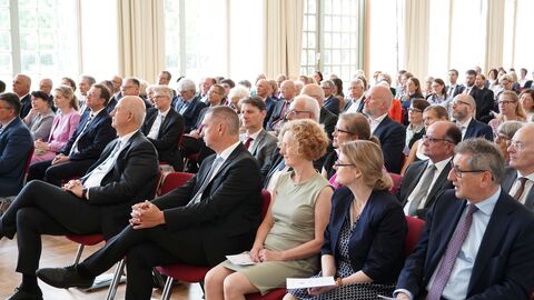 Amtswechselfeier Landessozialgericht Menschen sitzen nebeneinander auf Stühlen und schauen gespannt in die Richtung des Redners