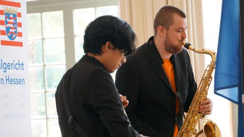 Amtswechselfeier Landessozialgericht Zwei Musiker stehen nebeneinander und spielen Saxofon und Gitarre
