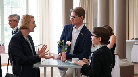 Amtswechselfeier Landessozialgericht 2 Frauen und ein Mann stehen an einem Stehtisch und unterhalten sich