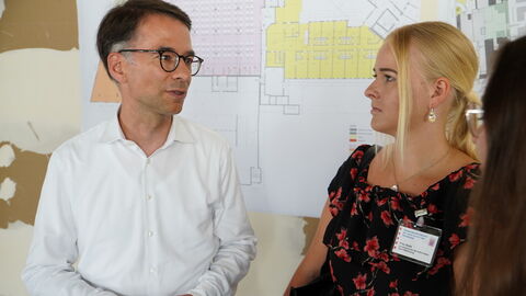 Justizminister Heinz unterhält sich mit einer Frau.