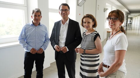 Justizminister Heinz besucht das Fritz-Bauer-Institut Justizminister Heinz steht mit einem Mann und zwei Frauen in einem Gang.