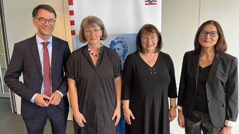 Justizminister Heinz steht mit drei Frauen vor einem Aufsteller mit der Aufschrift "Amtsanwaltschaft Frankfurt am Main"