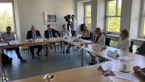 Justizstaatssekretärin Eichner im Gespräch Ein Koferenzraum mit vielen Personen sowie einem Kameramann. Dabei Justizstaatssekretärin Eichner.