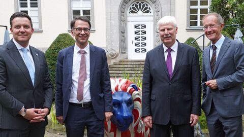 Vier Personen schauen in die Kamera