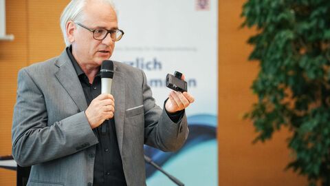 Mann hält Fußfessel in der Hand