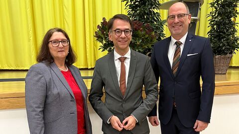 Sabine Dörr, Justizminister Heinz und der ehemalige Präsident Harald Wrack stehen gemeinsam vor einer Bühne zum Foto aufgestellt.