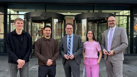 Justizminister Christian Heinz bei seinem Besuch am Amtsgericht Kassel mit weiteren Personen vor dem Gebäude.