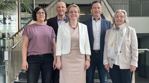 Justizstaatssekretärin Tanja Eichner steht mit weiteren Personen auf einer Treppe.