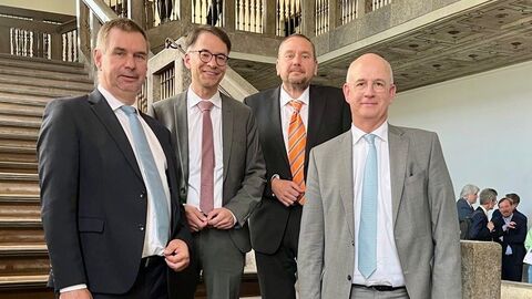 Justizminister Christian Heinz steht mit Professor Dr. Carsten Paul und seinem Vorgänger Dr. Wilhelm Wolf auf den Treppenstufen des Hessischen Landessozialgerichts