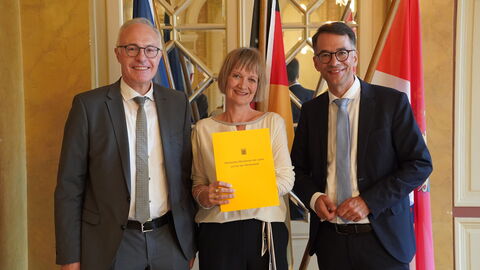 Justizminister Heinz überreicht die Urkunde an Claudia Bohn.