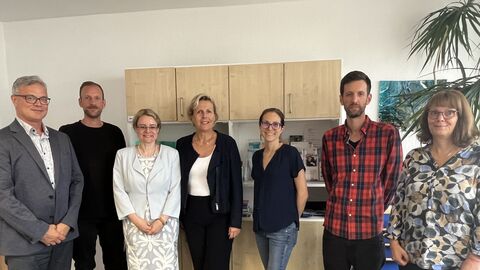 Justizstaatssekretärin Tanja Eichner steht mit 6 weiteren Personen in einer Reihe.