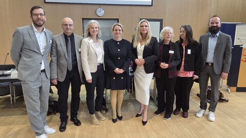 Staatssekretärin Eichner steht mit einer Gruppe in einem Raum.